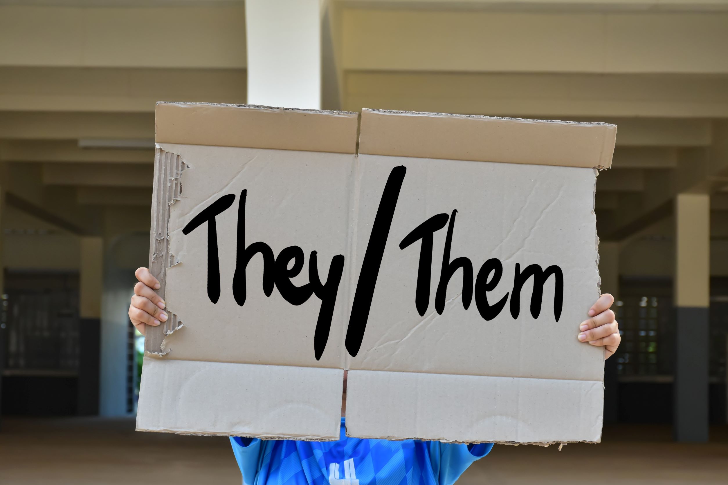 Person holding they/them pronoun sign | WorldStrides Canada